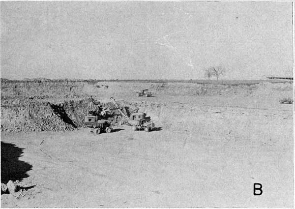 Black and white photo of quarry face; large shovel loading a truck.