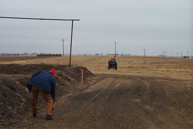 ATV holds cable reels, moves along line of stakes