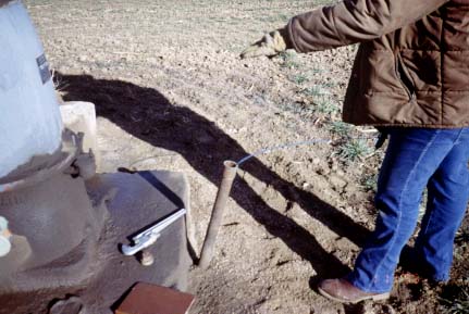 slant pipe extending from ground with measuring tape in it